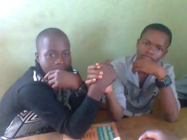 Two classmates arm wrestling at a desk